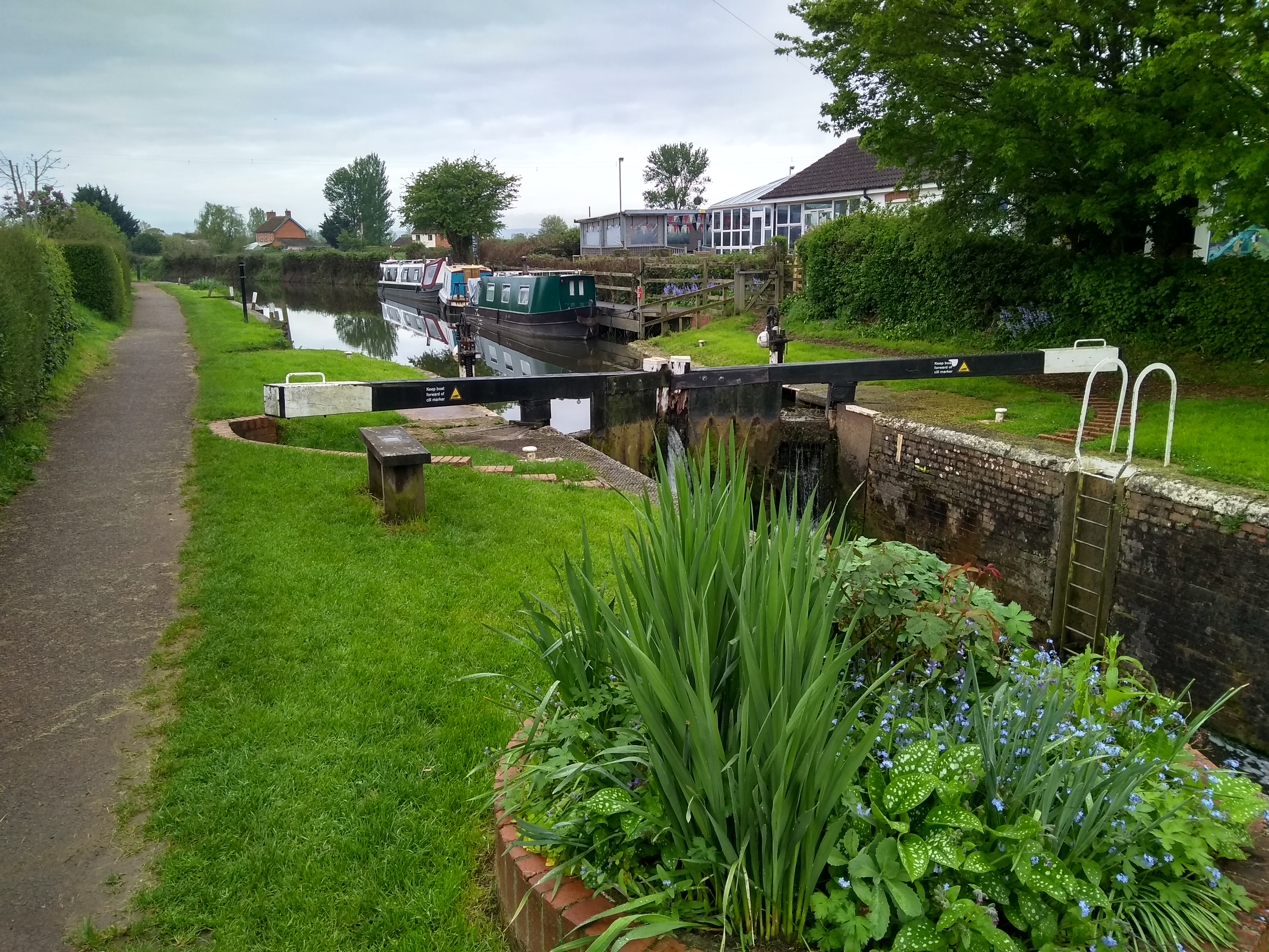 Canal lock with narrowboats in the background